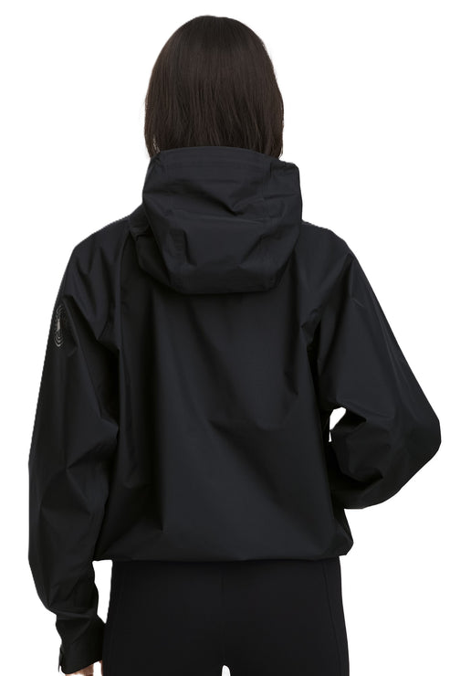 Back view of a person wearing a black jacket with a hood.