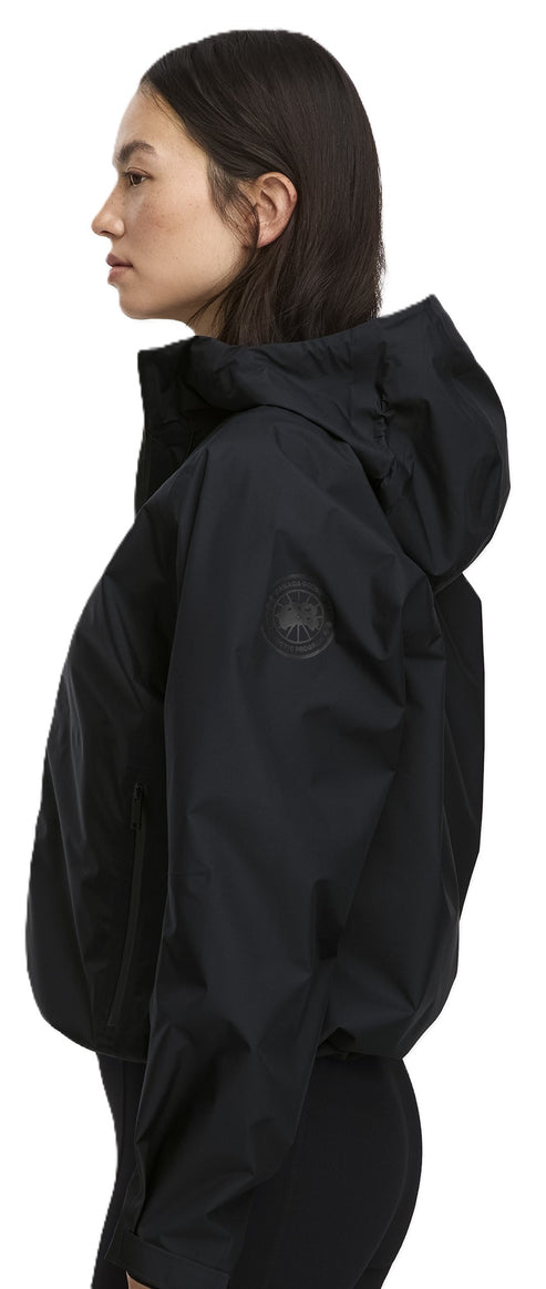 A person wears a black jacket with a hood.