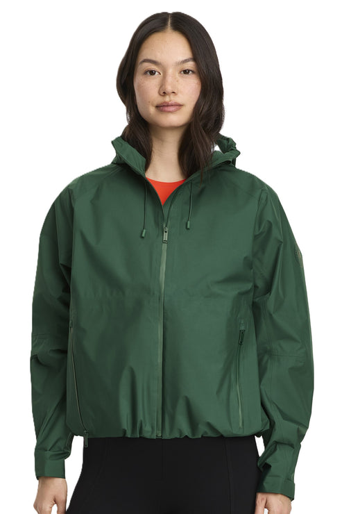 Woman in hooded, dark-green rain jacket.