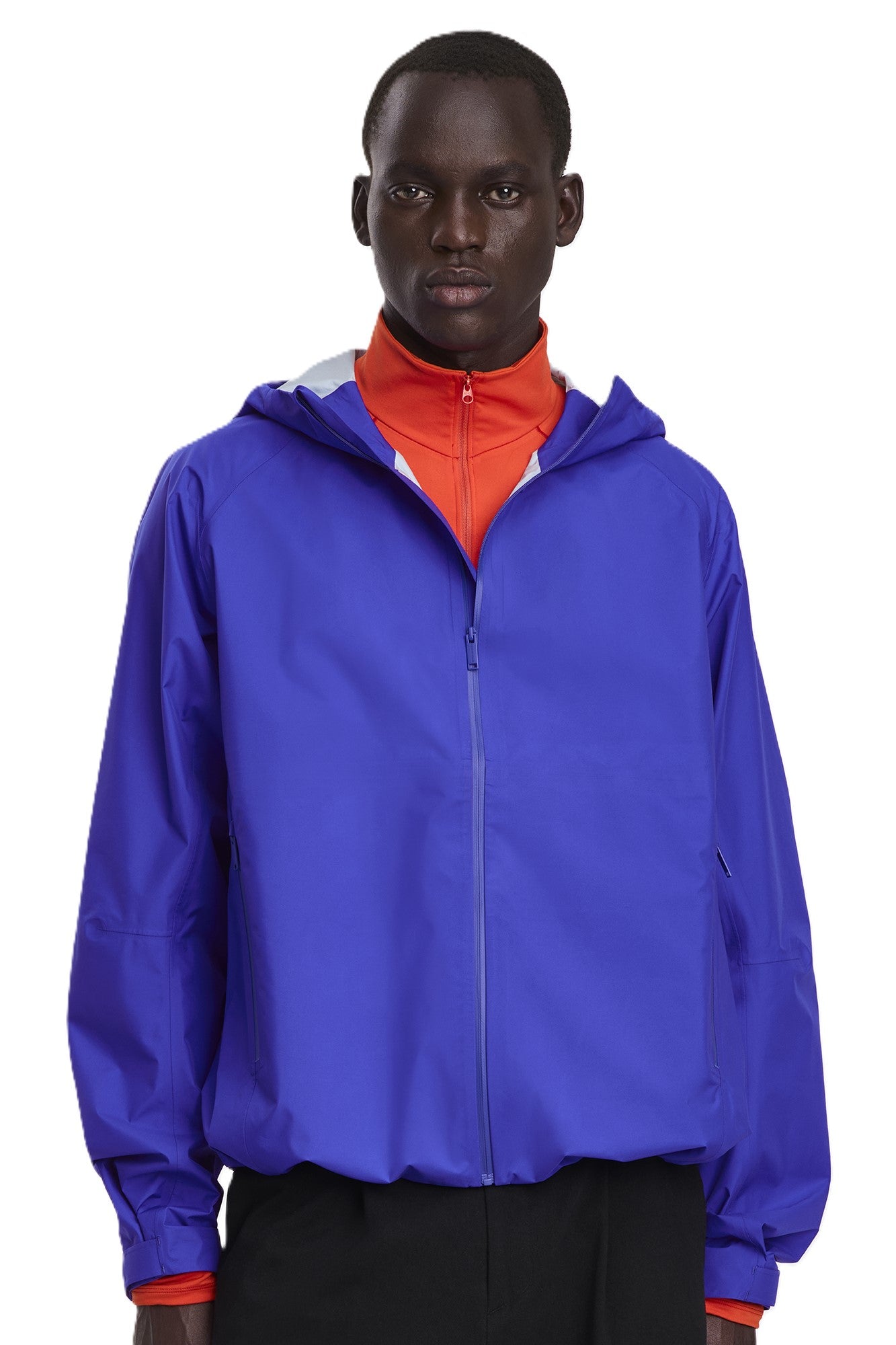 A person wearing a bright blue hooded jacket with a zipper front.