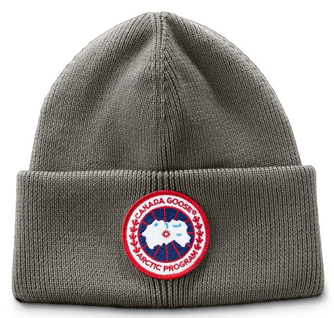 Gray knitted beanie with a red and white circular emblem that reads 'CANADA GOOSE ARCTIC PROGRAM'.