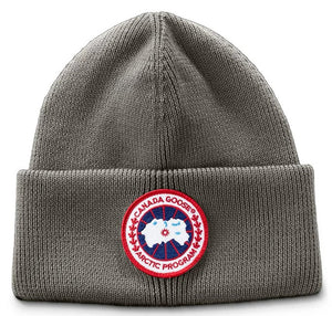 Gray knitted beanie with a red and white circular emblem that reads 'CANADA GOOSE ARCTIC PROGRAM'.