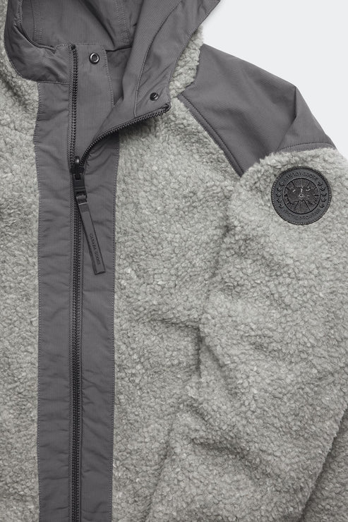 Gray sherpa jacket with dark gray accents and round logo patch on the sleeve.