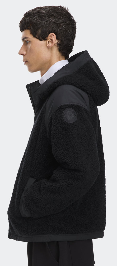 A person wearing a black hooded jacket.