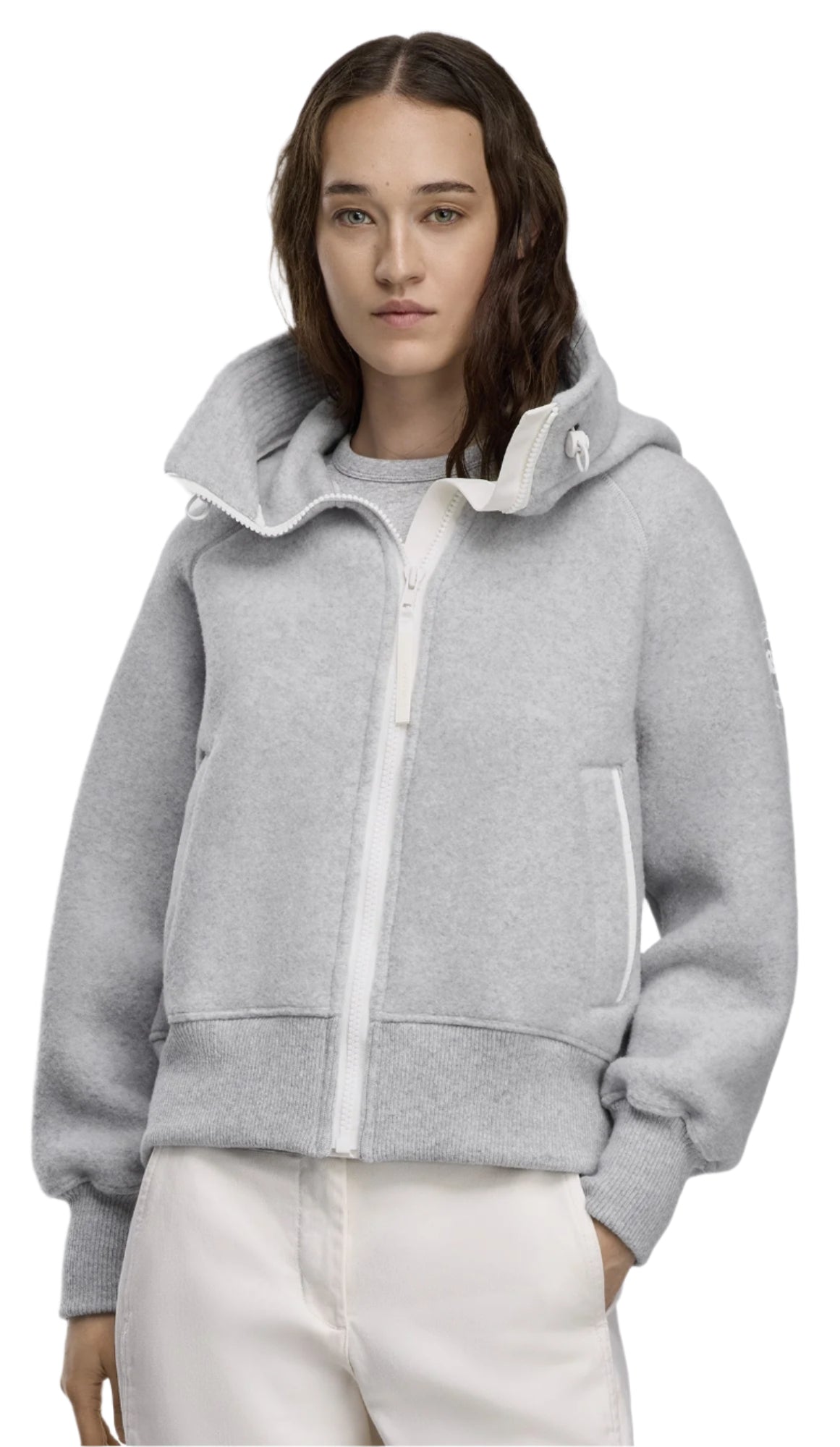 A woman wearing a gray hooded wool zip-up jacket with white zipper and trim.