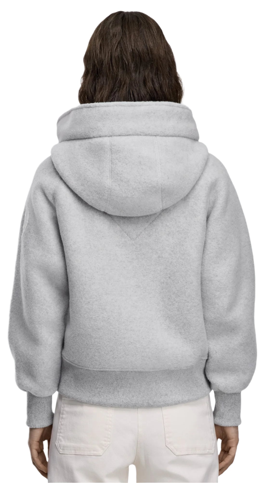 Back view of a person wearing a gray, furry hoodie with cuffed sleeves and white pants.