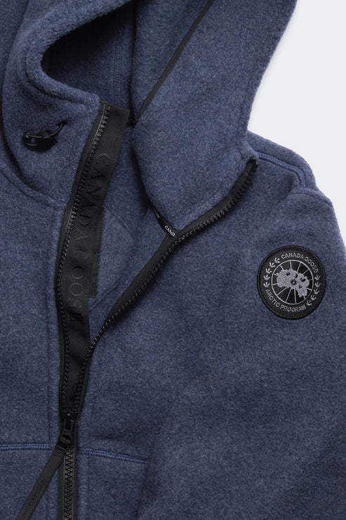 Close up of blue, zip-up, hooded sweatshirt with emblem.