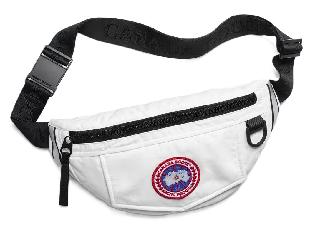 White fanny pack with a black zipper, adjustable black strap with repeating white text, and a circular logo with red lettering and a map of the arctic region.