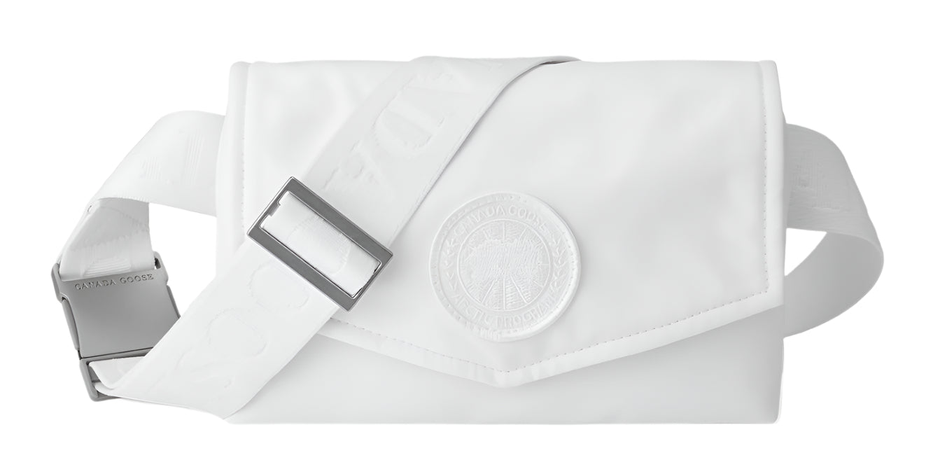 A white fanny pack with adjustable strap and a large round decorative medallion.