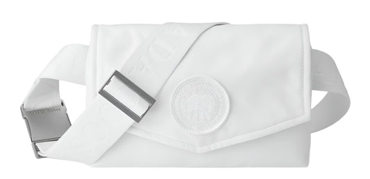 A white fanny pack with adjustable strap and a large round decorative medallion.