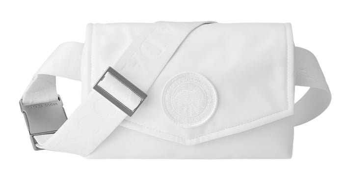 A white fanny pack with adjustable strap and a large round decorative medallion.