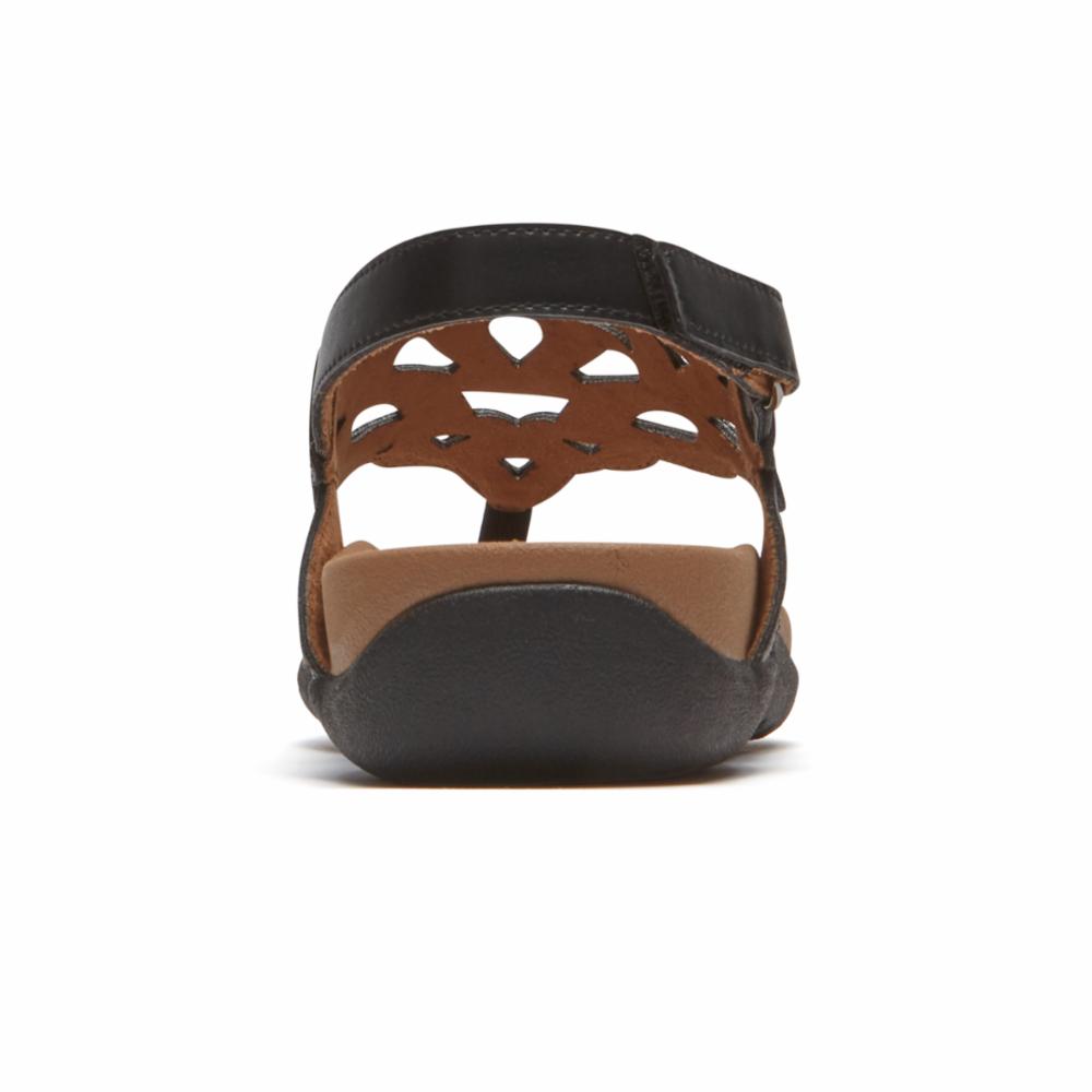 Black sandal rear view with adjustable ankle strap and decorative cutout pattern.
