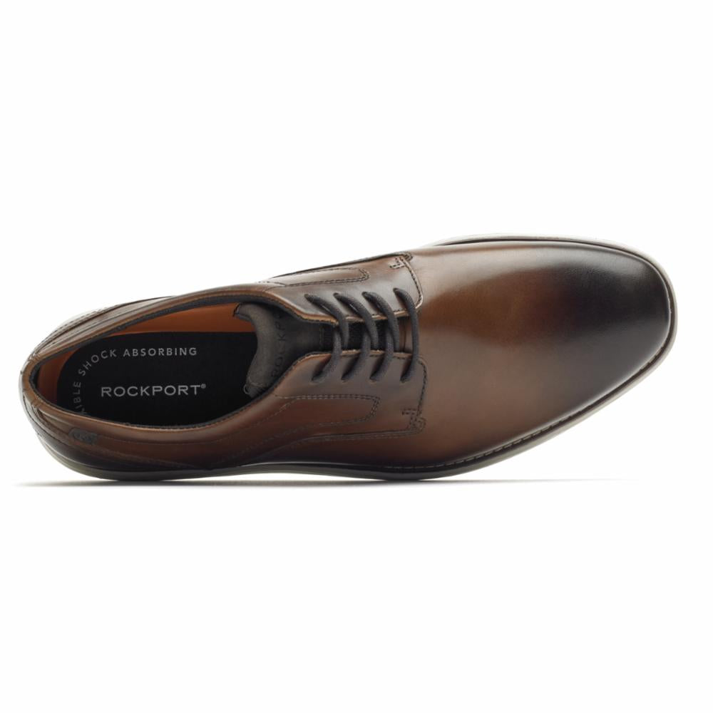 Brown leather dress shoe with black laces; ROCKPORT visible on inner sole.