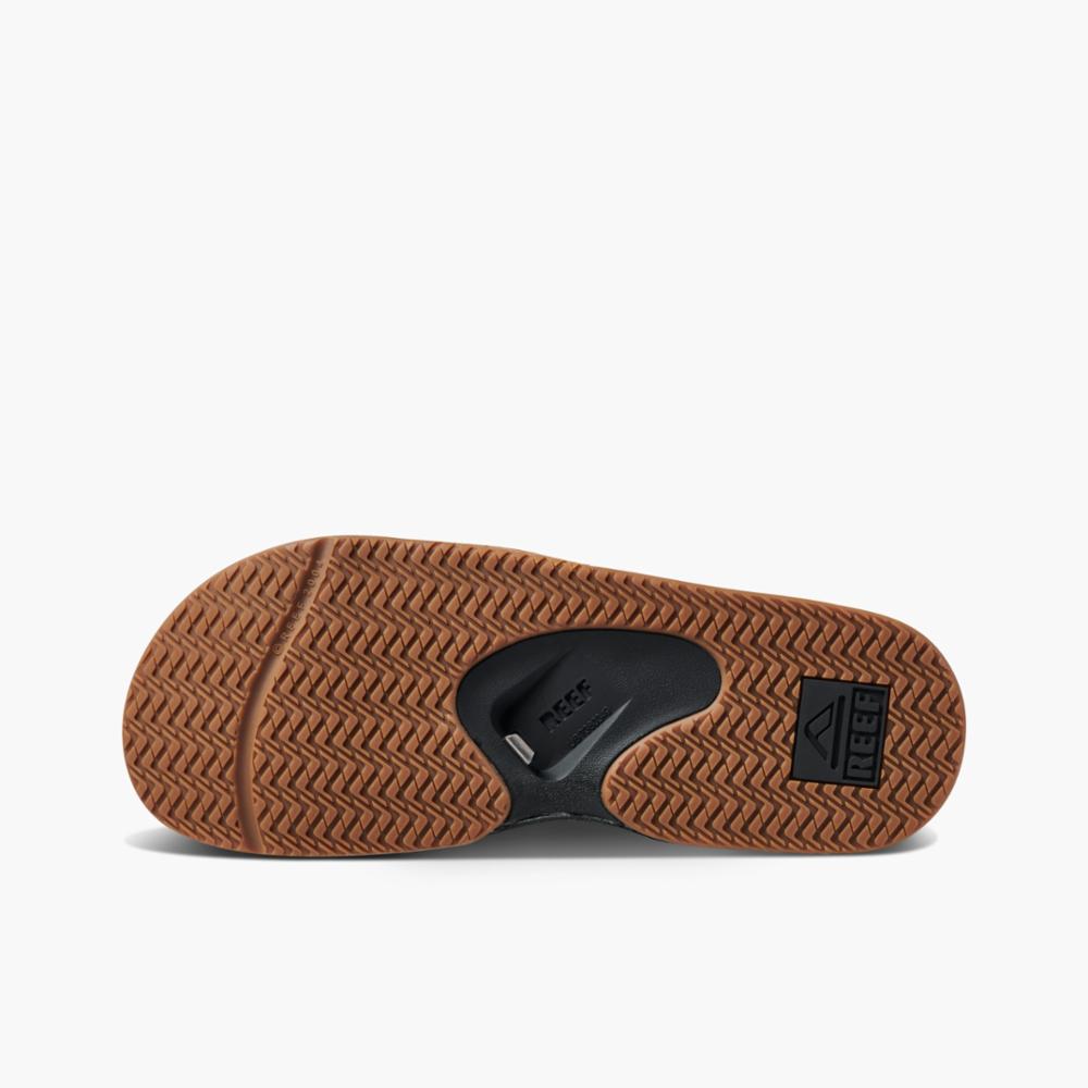 Brown sandal bottom featuring a dark, branded heel pad, bottle opener, and textured design.