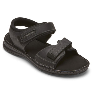 Black leather sandal with two adjustable hook-and-loop straps, and the word "ROCKPORT" on the ankle strap.