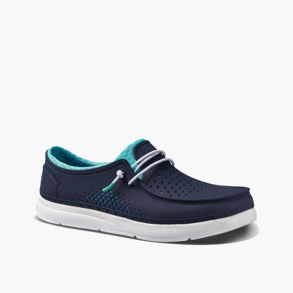 Navy blue rubberized slip-on shoe with turquoise lining, white laces, perforated upper, and white sole.