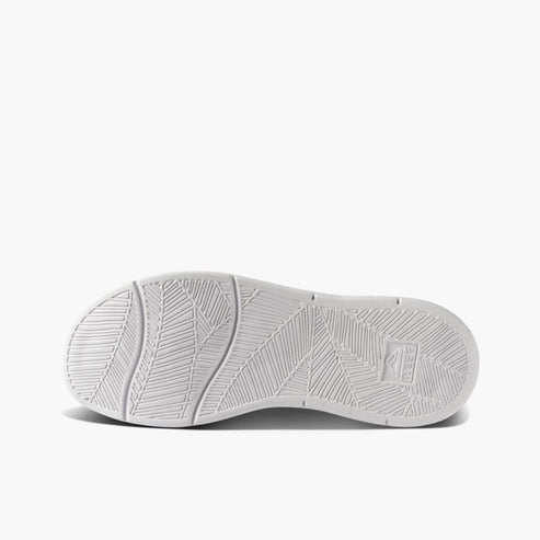 Sole of a white sneaker with textured geometric pattern.