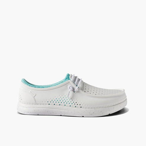 White casual shoe with white laces and teal lining.