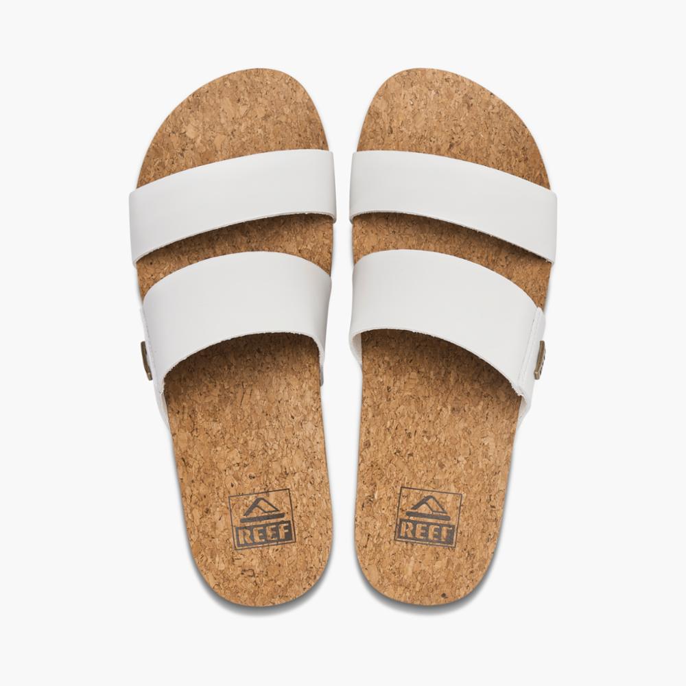 Pair of white, cork sandals with two straps each and logos on the footbeds.