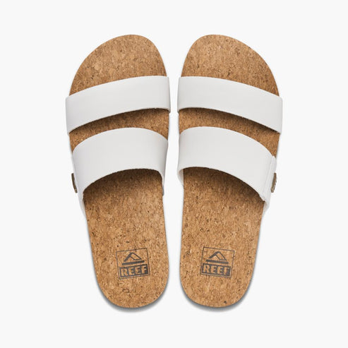 Pair of white, cork sandals with two straps each and logos on the footbeds.