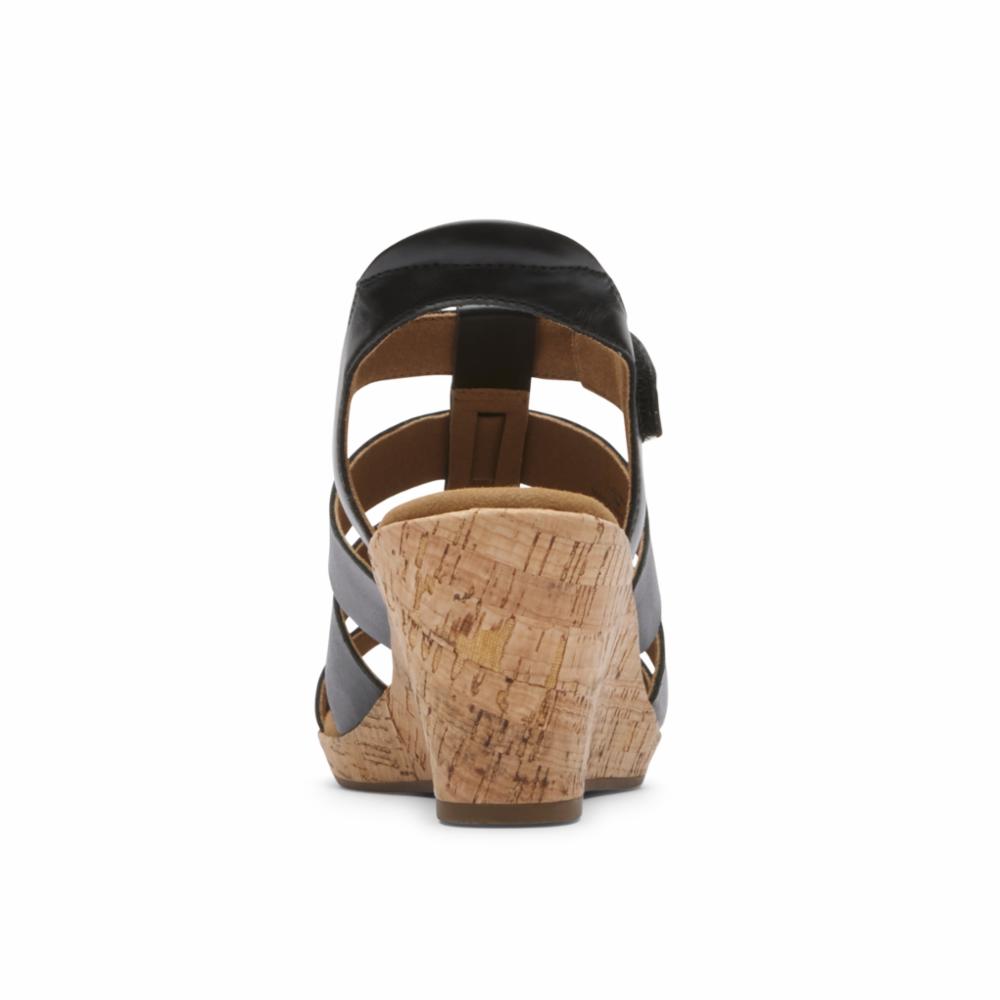 Black wedge sandal with cork heel and cross-strap design.