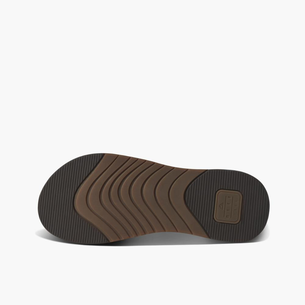 Brown sandal sole with curved wave pattern.