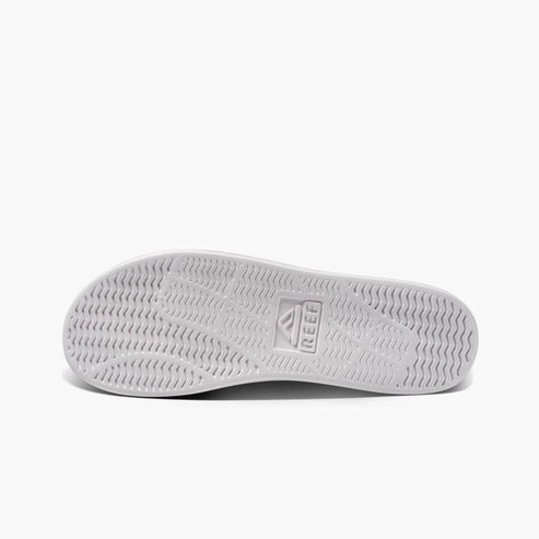 White shoe sole with REEF logo and wave-patterned texture.