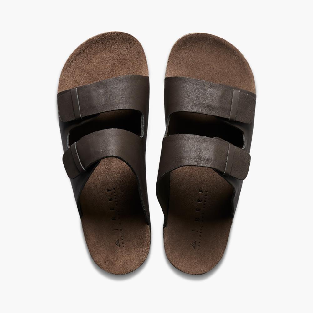 Pair of brown two-strap slide sandals with adjustable buckle.
