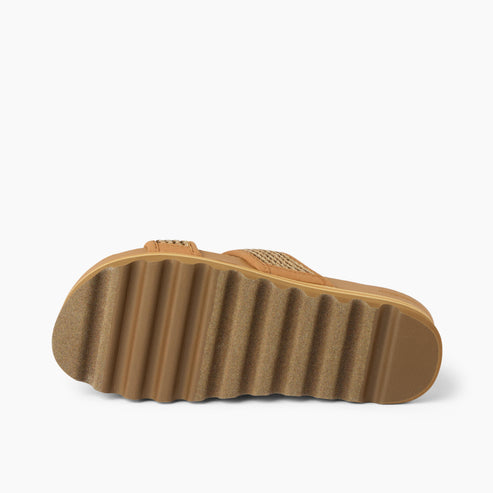 Angled view of a tan sandal with a ridged sole.