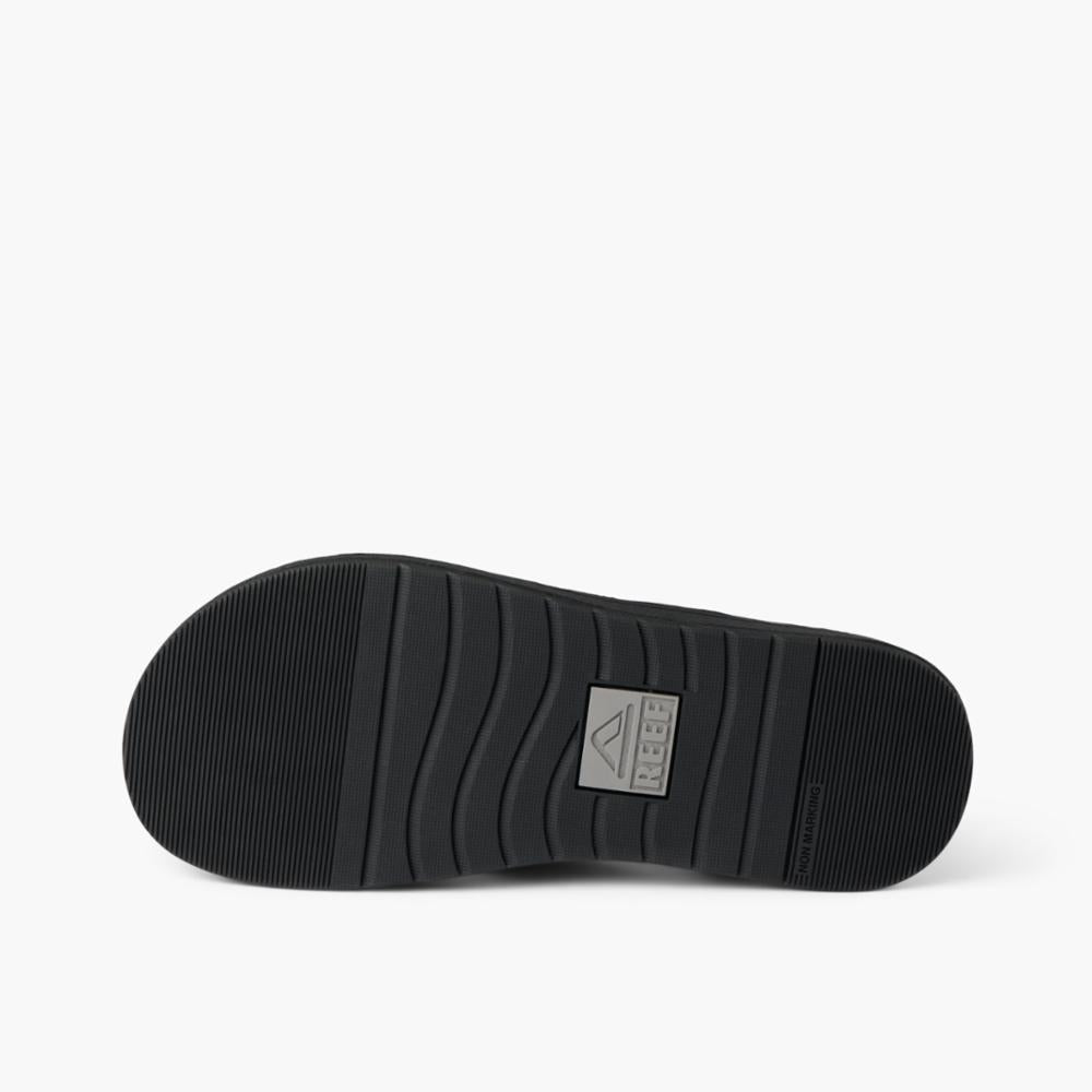 Bottom view of a black sandal sole with a logo.