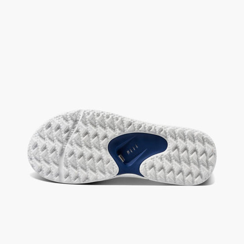 Bottom of a white and navy flip flop with heavy tread.