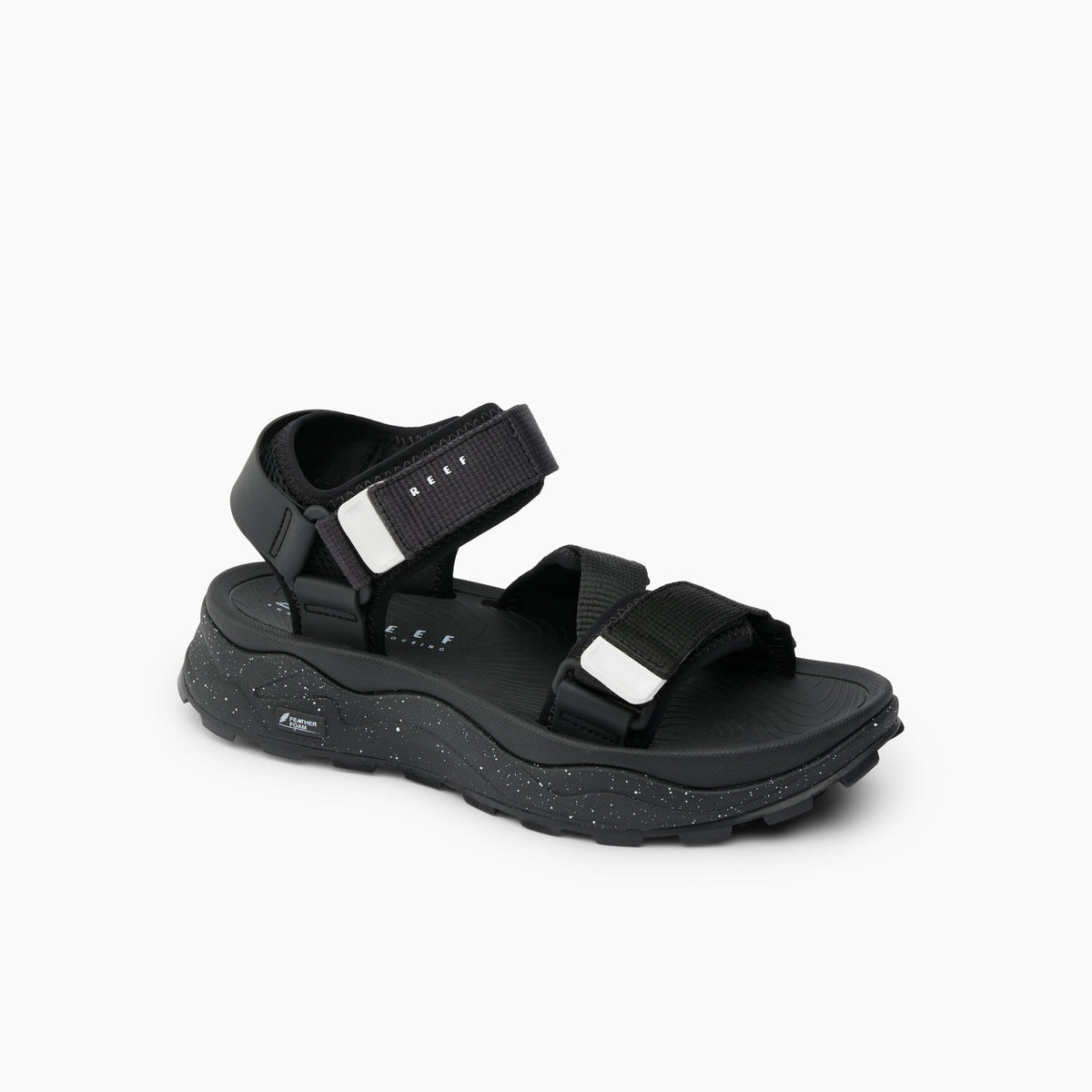 Black sandal with velcro straps and chunky, speckled sole.
