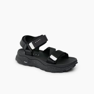 Black sandal with velcro straps and chunky, speckled sole.