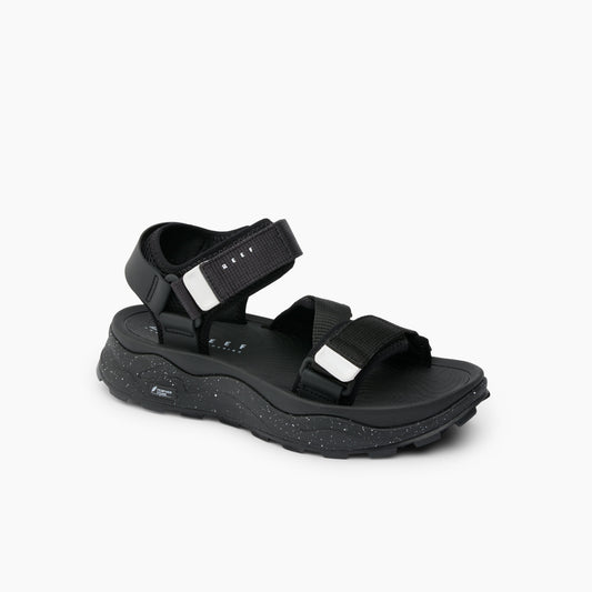 Black sandal with velcro straps and chunky, speckled sole.