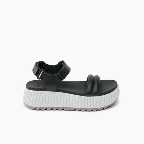 Black sandal with a hook-and-loop closure and a thick, ridged white and gray sole.