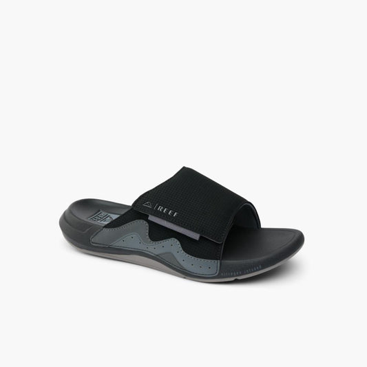 Black slide sandal with velcro strap and gray wavy design.