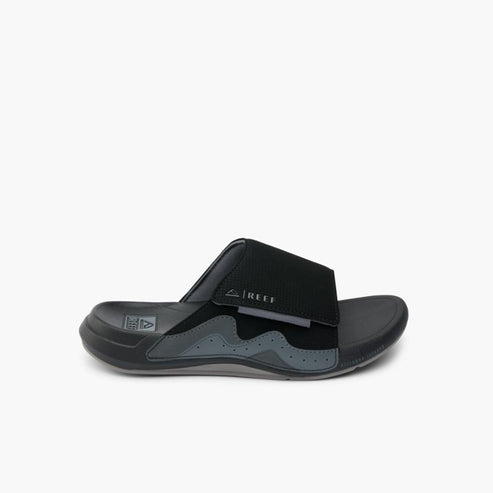 Black slide sandal with fabric upper strap and wavy design.