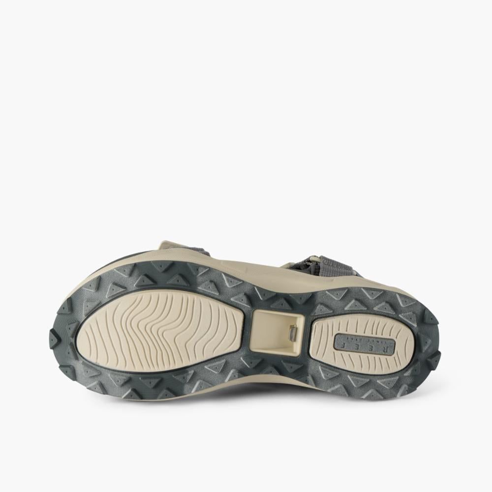 Gray sandal sole with patterned treads.