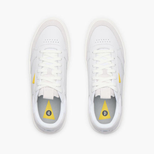A pair of white tennis shoes with a yellow triangle on the insole.