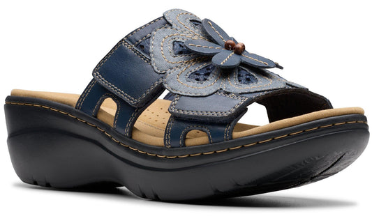 Navy blue wedge sandal with flower accent and adjustable straps.