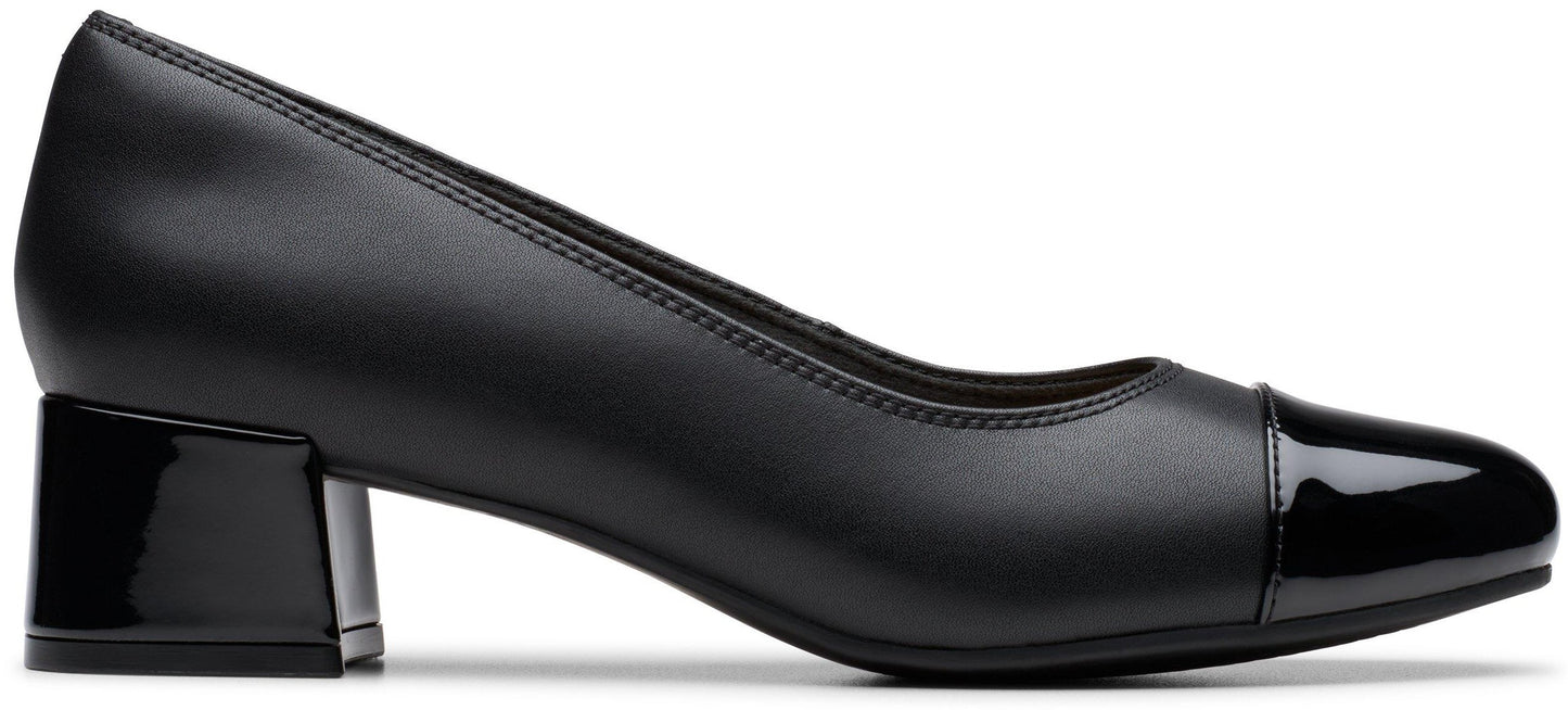 A black leather women's low-block heel pump shoe with a glossy patent leather toe cap and a matching glossy block heel, shown in a side profile view.