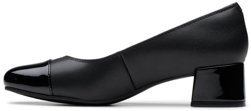 A black leather block-heeled pump with a rounded toe, featuring a glossy patent leather toe cap and matching patent leather block heel.