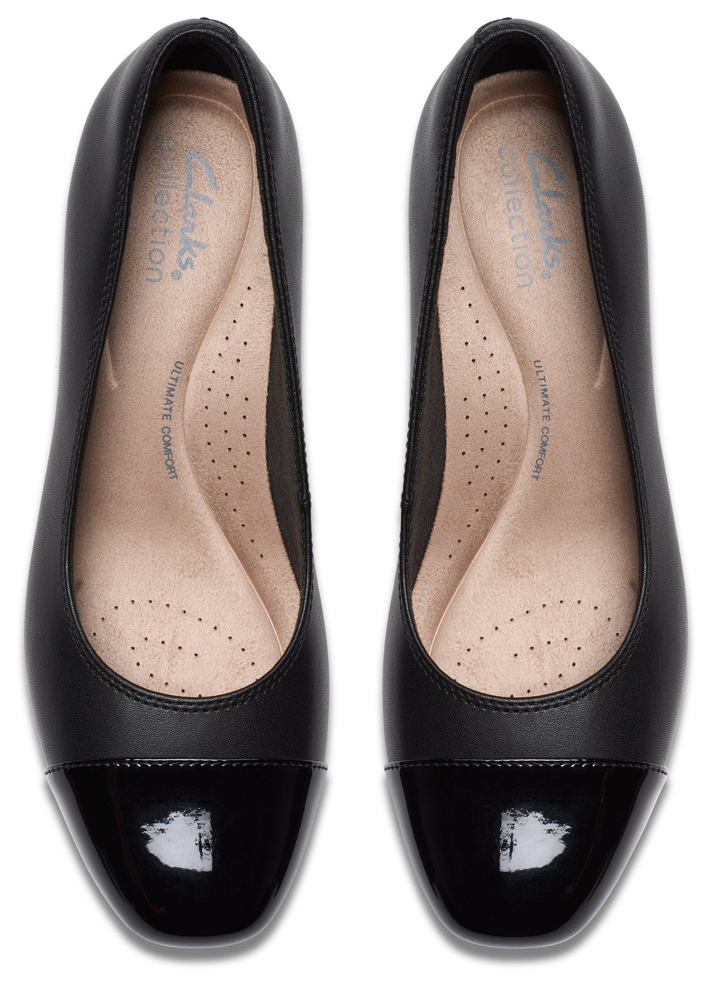 A pair of black cap-toe pumps viewed from directly above, featuring a matte black body and a glossy black patent leather toe cap, with beige insoles marked with 'Clarks Collection' and 'Ultimate Comfort' text.