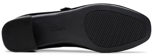 The black textured rubber outsole of a shoe with a low block heel and the word Clarks embossed in the center of the arch.