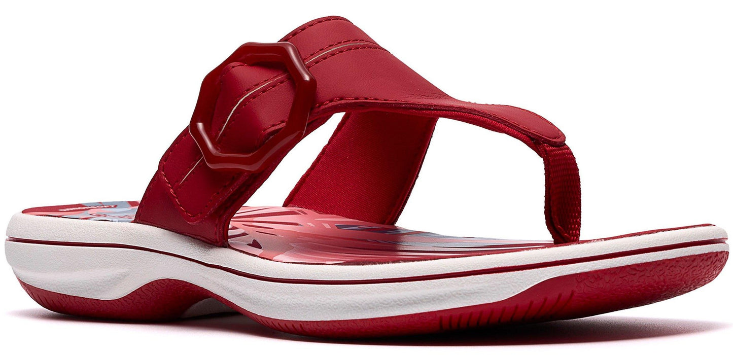 Red sandal with a white and red sole and a decorative buckle.