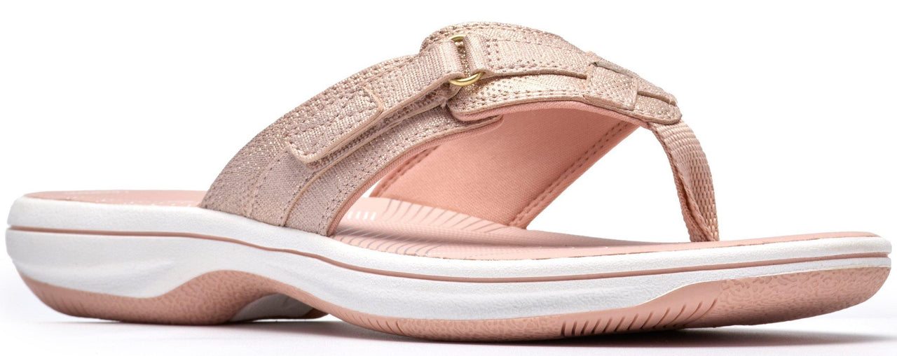A rose gold sandal with white sole.