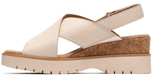 Beige sandal with criss-cross straps and cork wedge heel.