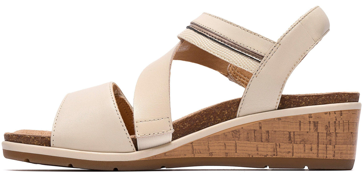 A women's wedge sandal with a cork-covered heel and beige leather straps.