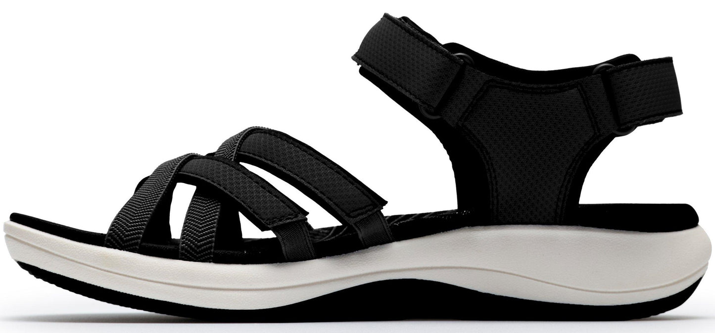 Side view of a black sandal with white sole and adjustable straps.