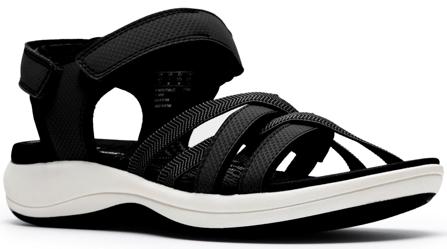 A women's sandal with an adjustable velcro heel strap and multiple crossing black straps over the toes on a white sole.